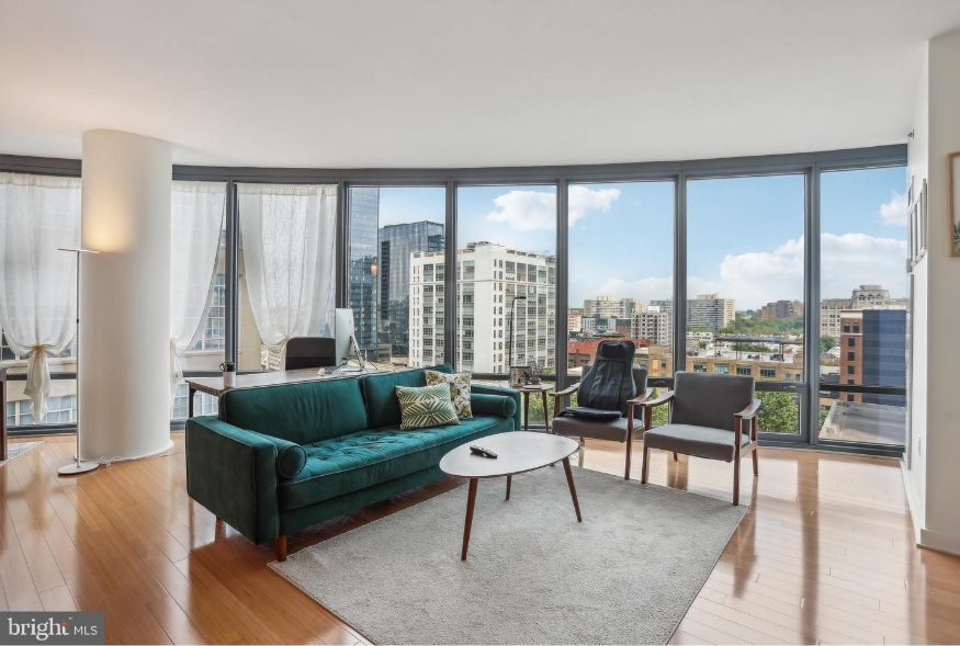 The Murano Condominiums Living room with a wall of floor to ceiling windows 